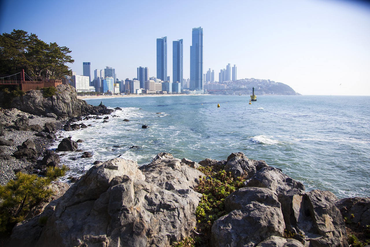 from a rocky coast you look over the sea to the skyline of Busan